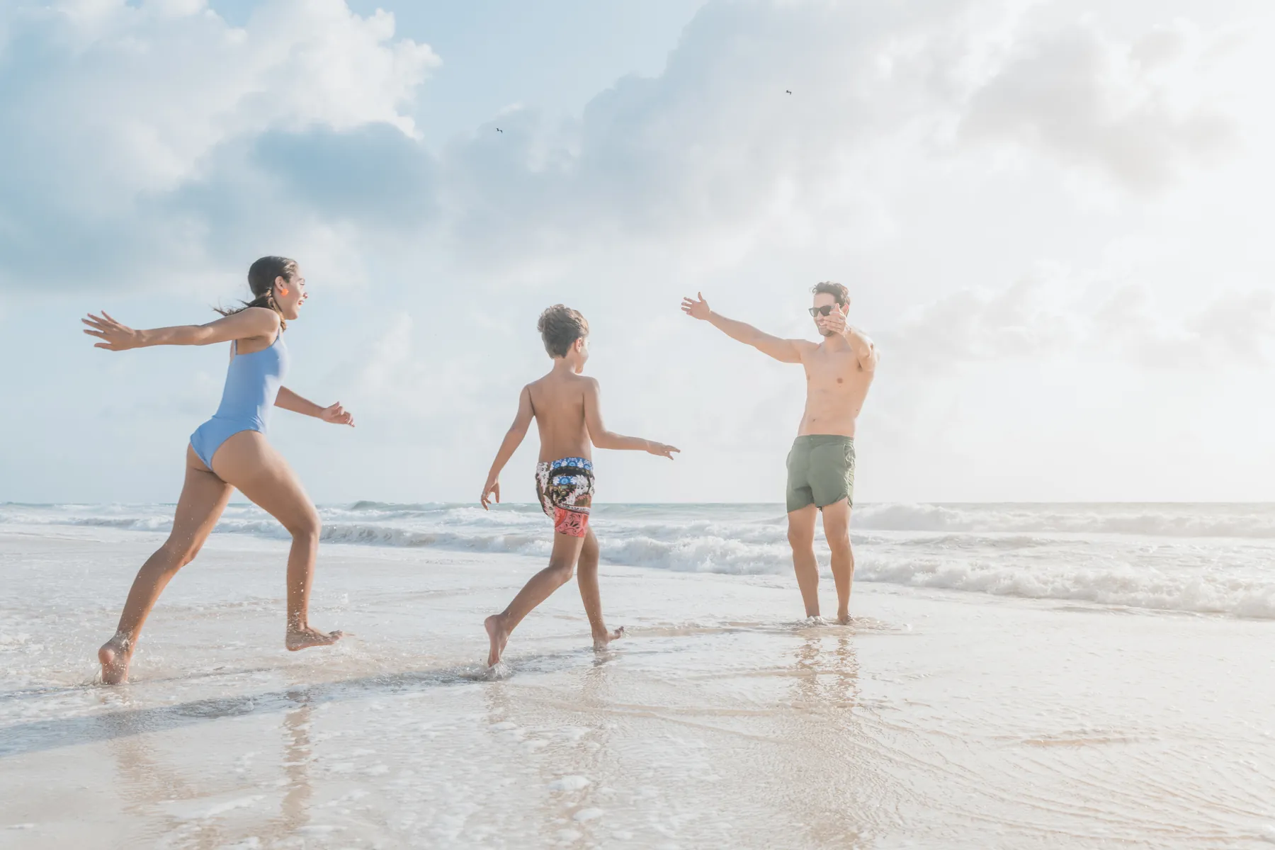 Family running on the beach at an Iberostar resort in Cancún