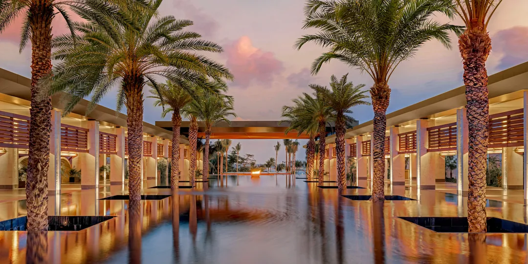Reflecting pool and palm-lined architecture at dusk, Conrad Tulum Riviera Maya